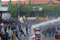 CHAOS. Potret demo ricuh ketika mahasiswa hendak maju melewati batas pagar kawat yang dipasang polisi, hingga polisi tembakkan water cannon ke arah massa aksi demonstrasi di depan Gedung DPRD Jatim, Surabaya, Senin (17/2/2025). (doc.Risky/suarasurabayanet/Linkking.id)