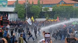 CHAOS. Potret demo ricuh ketika mahasiswa hendak maju melewati batas pagar kawat yang dipasang polisi, hingga polisi tembakkan water cannon ke arah massa aksi demonstrasi di depan Gedung DPRD Jatim, Surabaya, Senin (17/2/2025). (doc.Risky/suarasurabayanet/Linkking.id)
