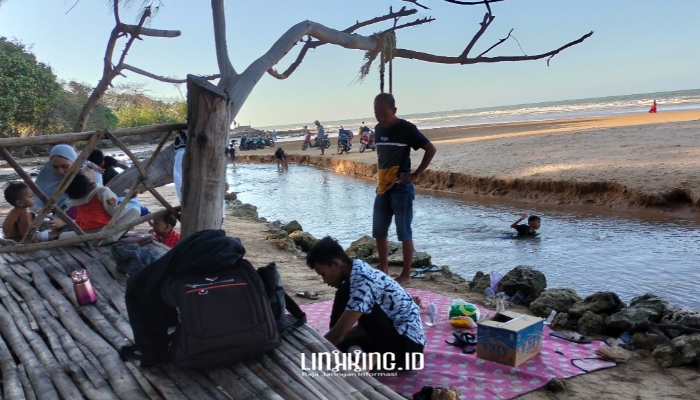 LIBURAN. Potret salah satu wisatawan asli Sumenep yang menikmati keindahan Pantai Badur. (Dok. Redaksi Linkking.id)