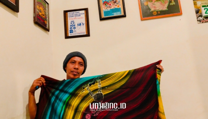 KARYA. Potret Owner Dermaga Batik, Moh. Erfan, saat menunjukkan karya batik kontemporernya dengan tema Ojhung. (Dok. Redaksi Linkking.id)
