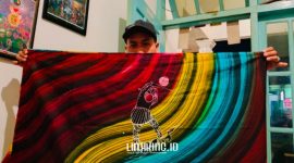 KARYA. Potret Owner Dermaga Batik, Moh. Erfan, saat menunjukkan karya batik kontemporernya dengan tema Ojhung. (Dok. Redaksi Linkking.id)
