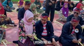 TRADISI: Bupati Sumenep, Ach. Fauzi bersama isteri ikut merangkai selongsong ketupat dengan para peserta pada acara Festival Ketupat. (Dok. linkking.id)